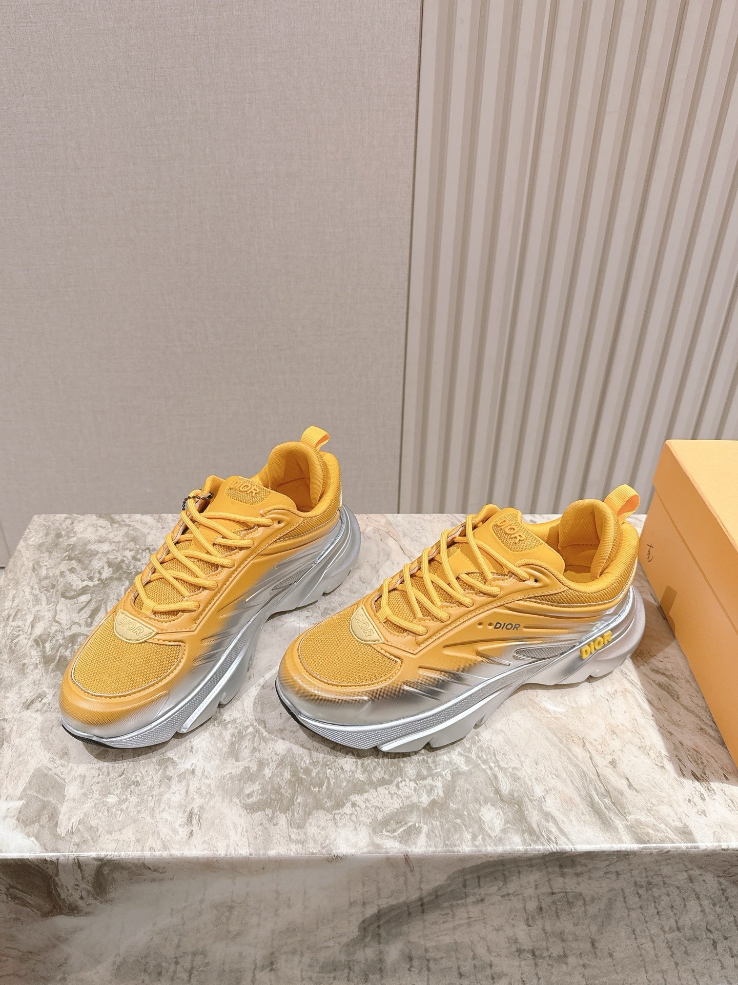 Dior unisex sneakers pair, yellow mesh upper with lace-up front and silver sole trim