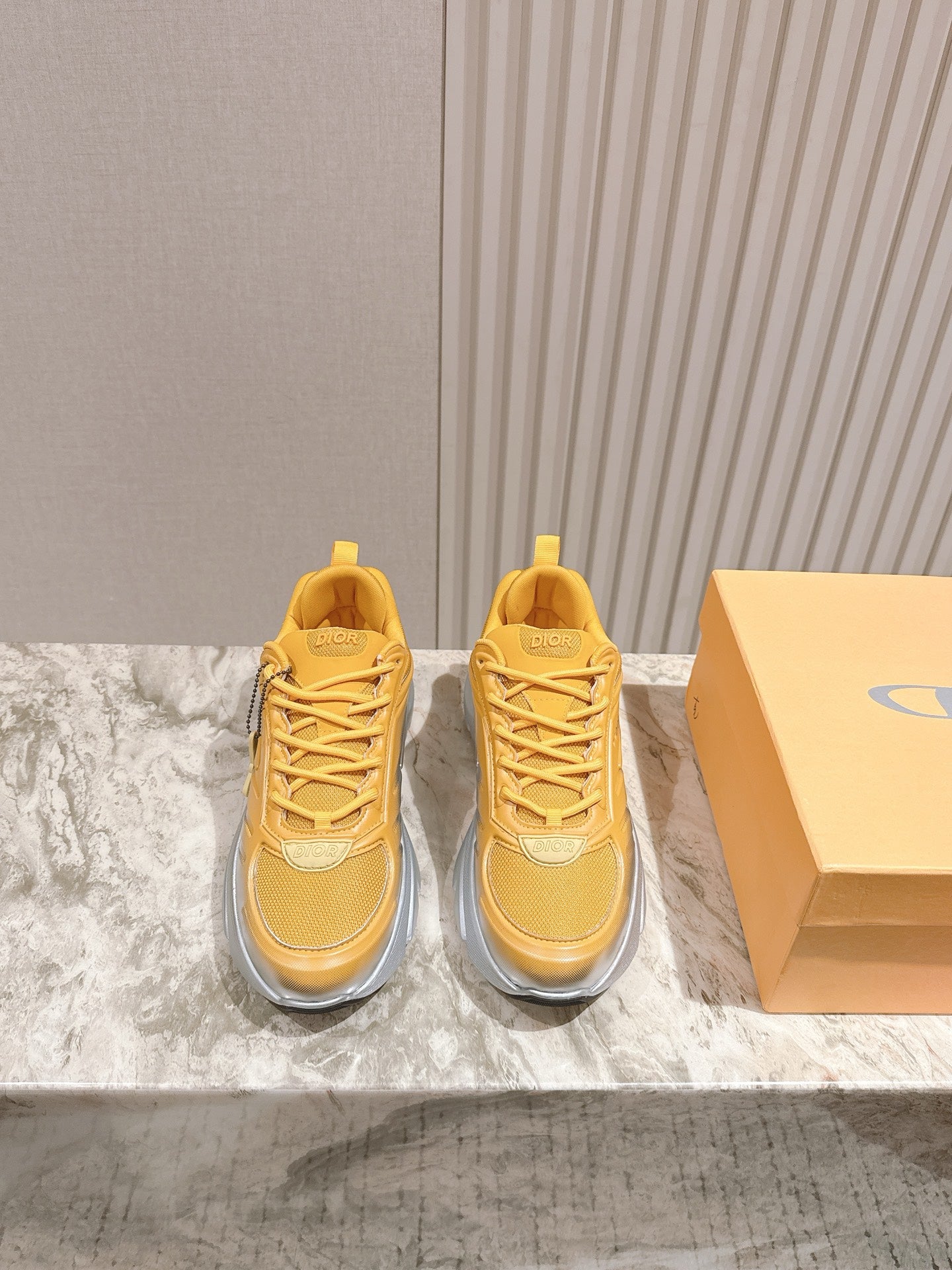 Dior unisex sneakers, yellow upper with gray cushioned soles and lace-up design