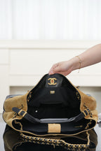 Two-tone Chanel tote with open top and black lining; tan exterior and quilted black base.