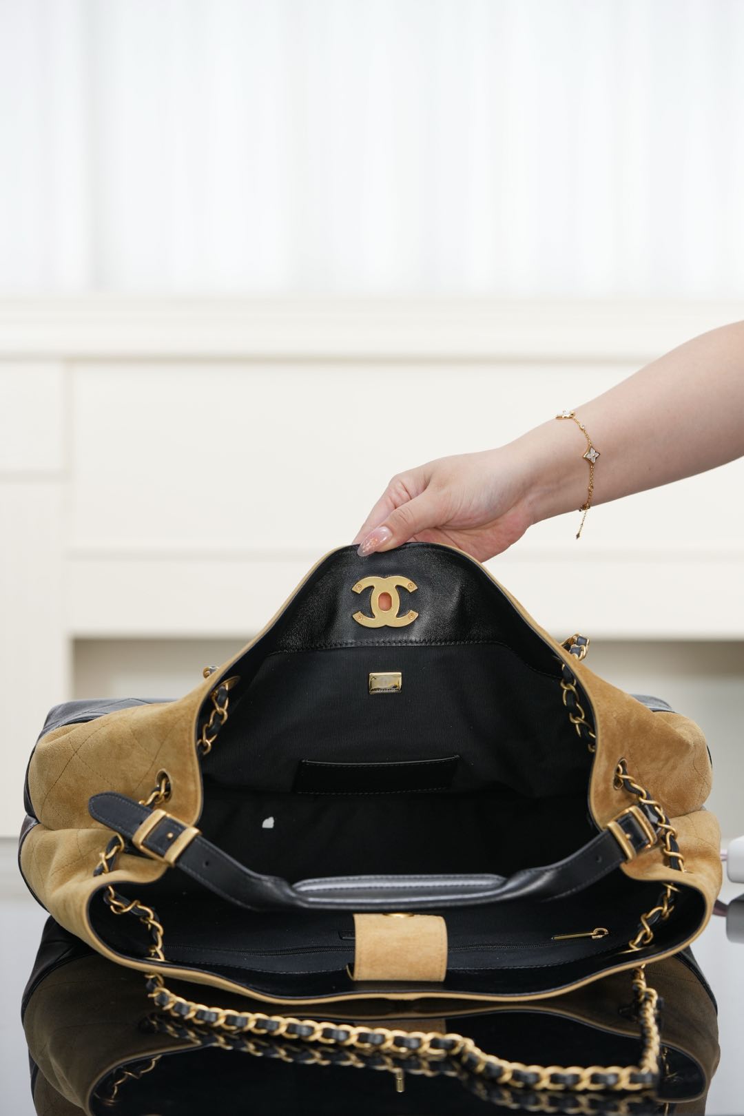 Two-tone Chanel tote with open top and black lining; tan exterior and quilted black base.