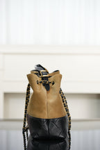 Back view of two-tone Chanel tote with tan panel, quilted black base, chain straps.
