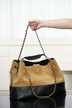 Two-tone Chanel tote with tan front, quilted black lower section, gold chain straps.