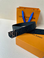 Black textured leather belt with embossed monogram and metal LV buckle, side view