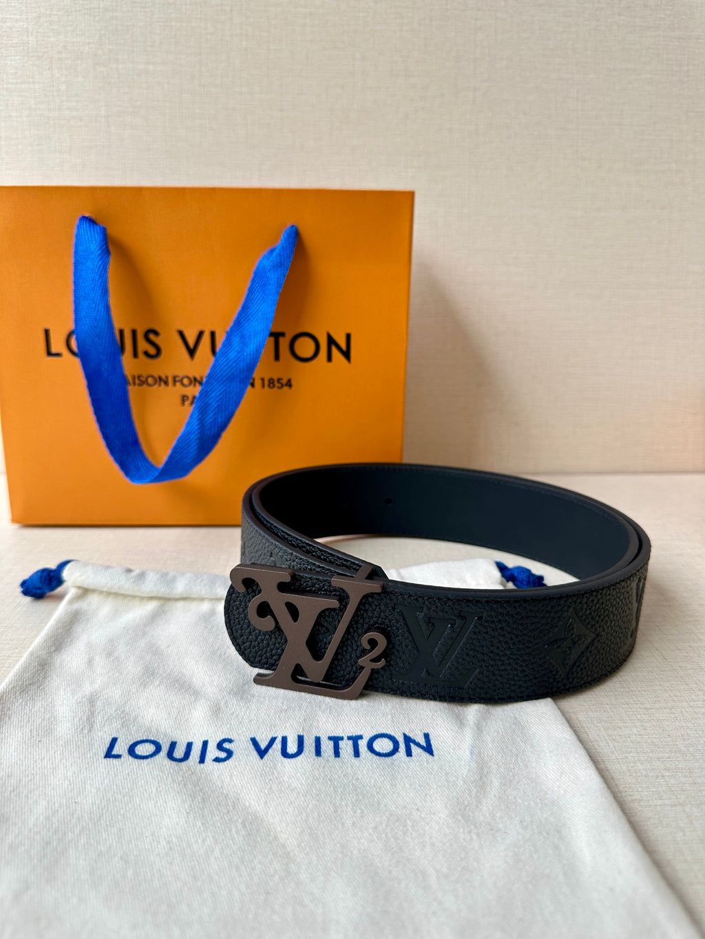Black monogram leather belt with metal LV buckle, flat lay