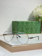 Gucci eyeglasses with round clear lenses and dark metal frames