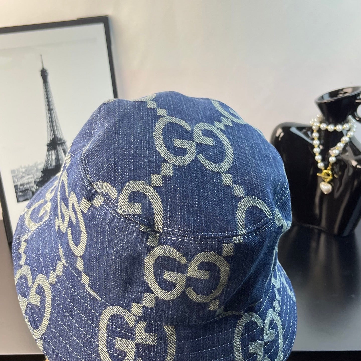 Gucci blue GG-pattern denim bucket cap, angled view of logo print