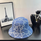 Gucci GG denim bucket hat in blue with repeating monogram pattern, angled view