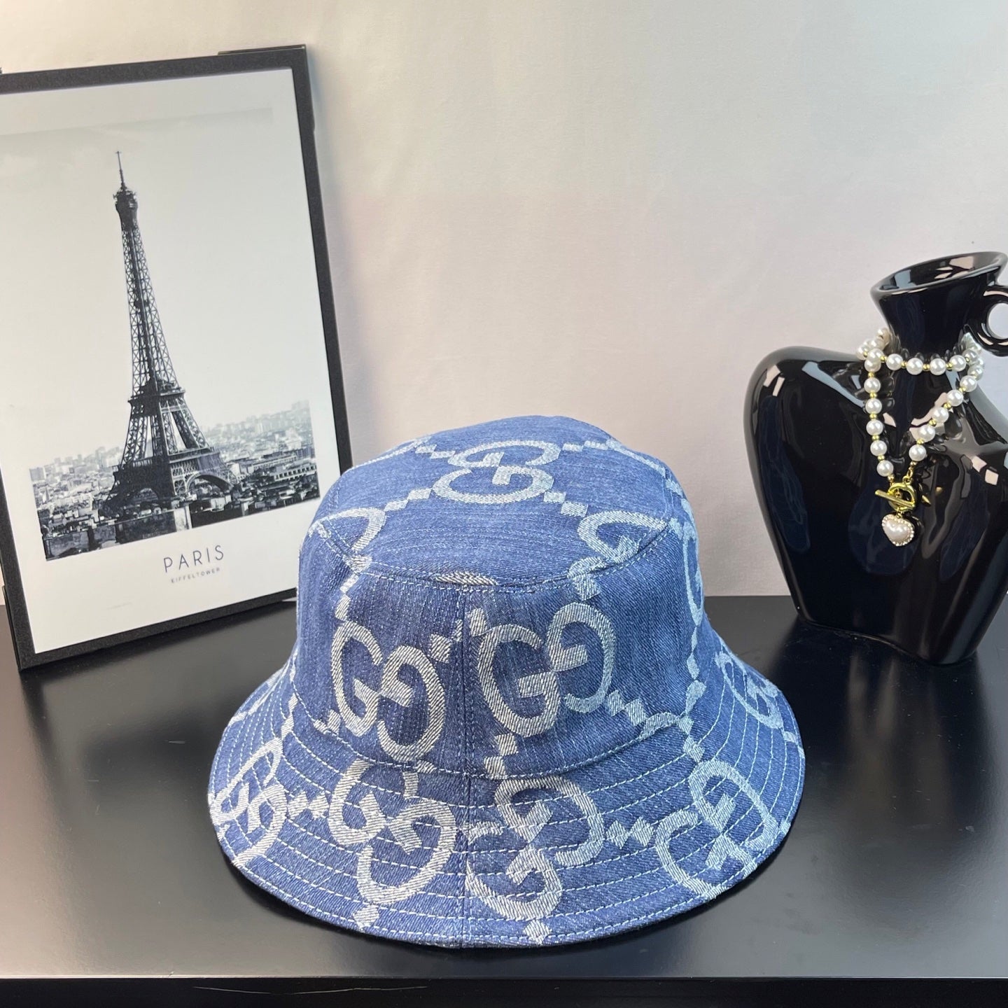 Gucci GG denim bucket hat in blue with repeating monogram pattern, angled view