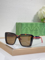 Brown-tinted square sunglasses with tortoise frame and red/green temple stripe.