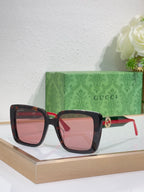 Pink-tinted square sunglasses with tortoise frame and red temple accents.