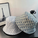 Dior bucket hats in light blue and dark blue with gold monogram-style pattern, paired