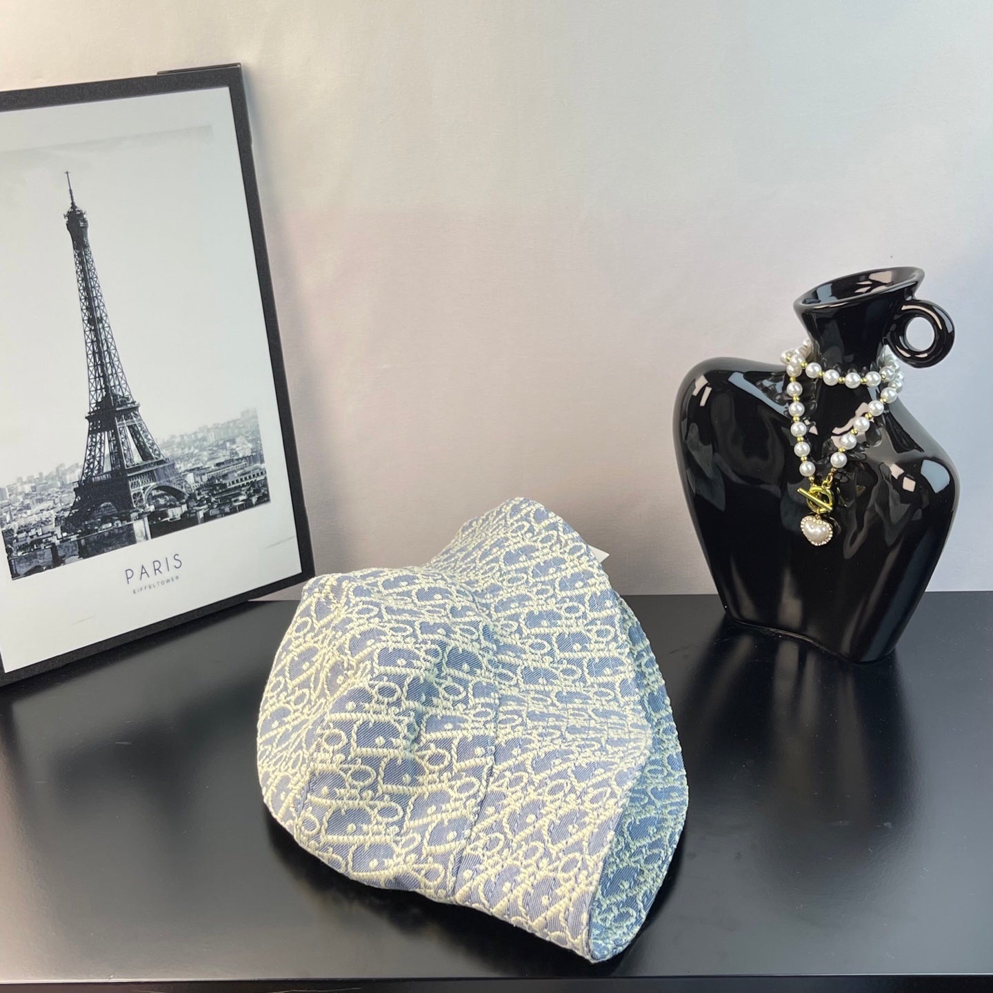Light blue monogram bucket cap with gold logo print, draped brim view