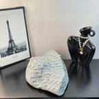 Dior bucket hat in light blue with white monogram pattern, folded on display