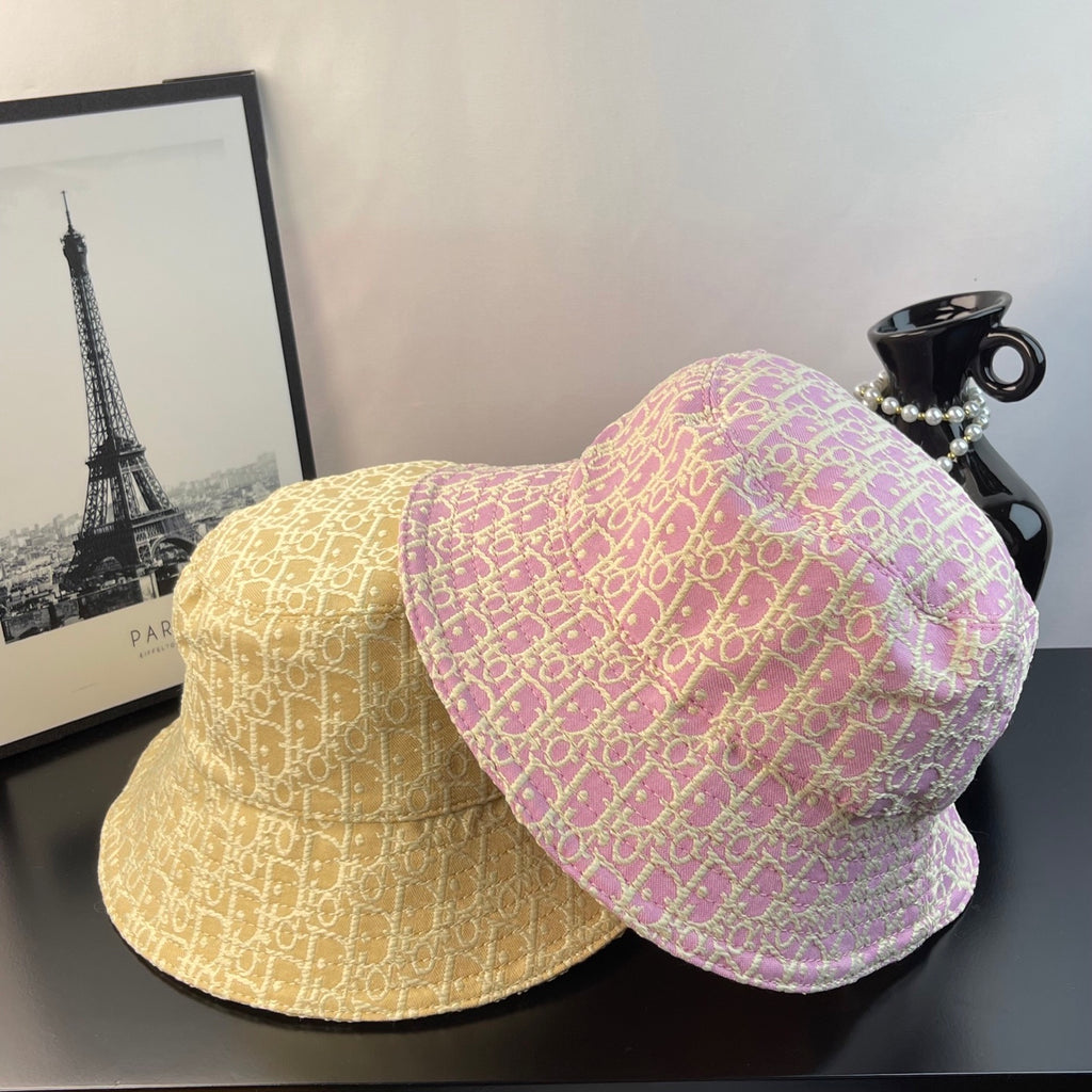 Dior monogram bucket hats: light gold and pink, both with curved brims