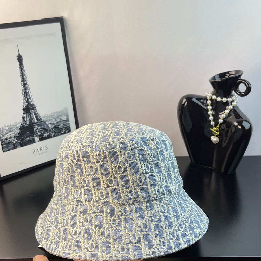 Gucci bucket hat in light blue with gold monogram pattern, angled view