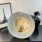 Light blue monogram bucket cap with gold pattern, interior lining and tags