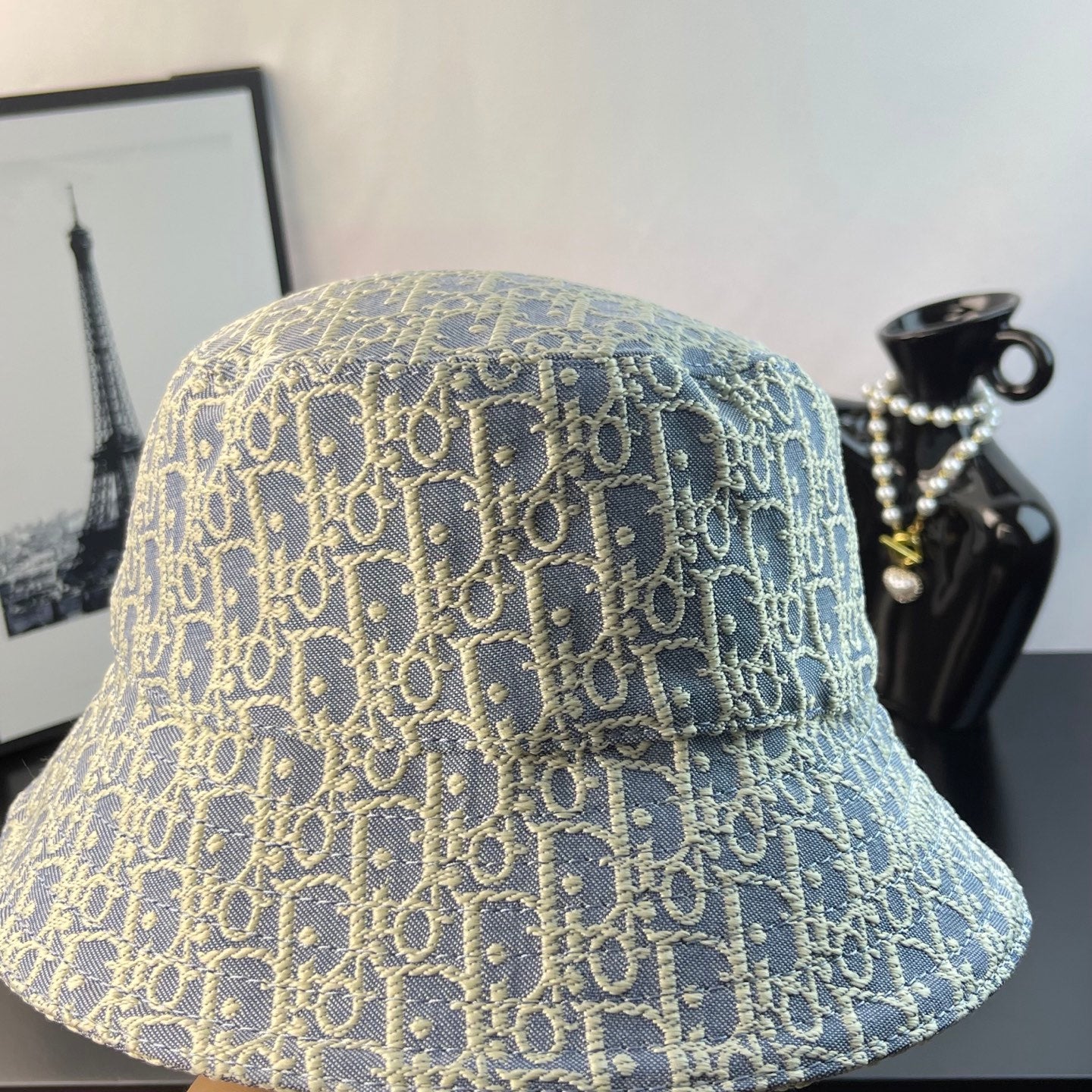 Light blue monogram bucket cap with gold logo pattern, side view
