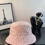 Gucci pink monogram bucket cap, angled view with textured pattern