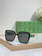 Gucci sunglasses with dark lenses and black square frame with gold accents