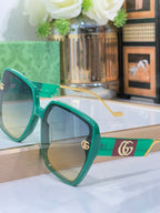 Gucci sunglasses with green frame, gradient lenses, and gold temple hardware