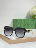 Gucci sunglasses with black frame, dark lenses, and gold GG logo details