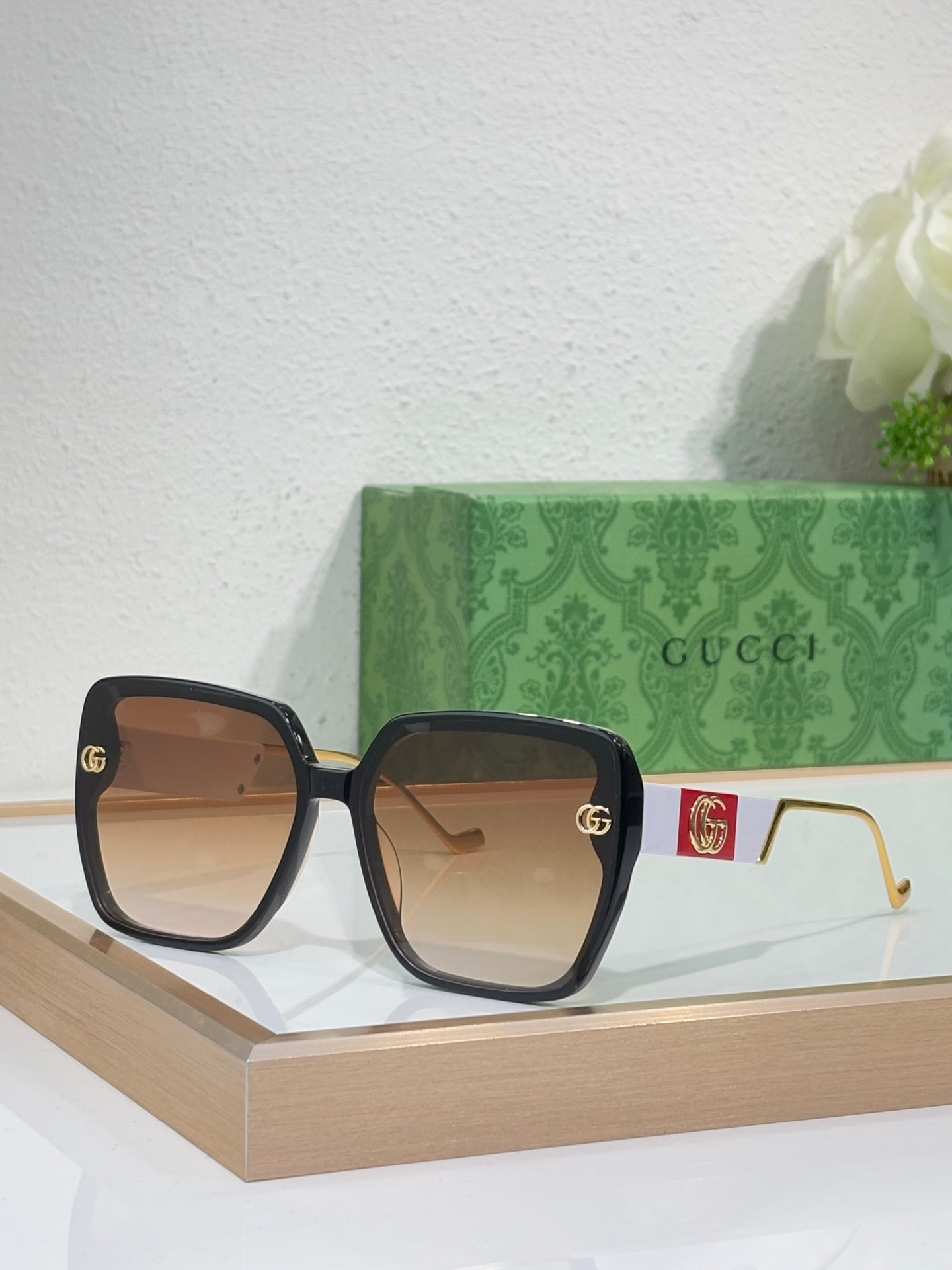Gucci sunglasses with tortoiseshell frame, tan lenses, and gold temple hardware
