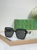 Gucci sunglasses with black oversized frame and dark tinted lenses