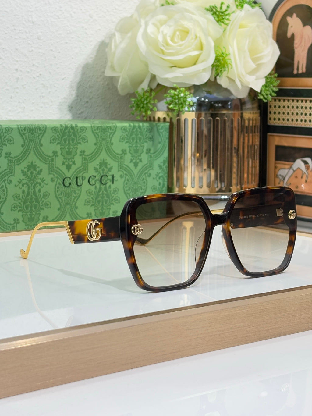 Gucci sunglasses with tortoiseshell frame, light gradient lenses, and gold logos