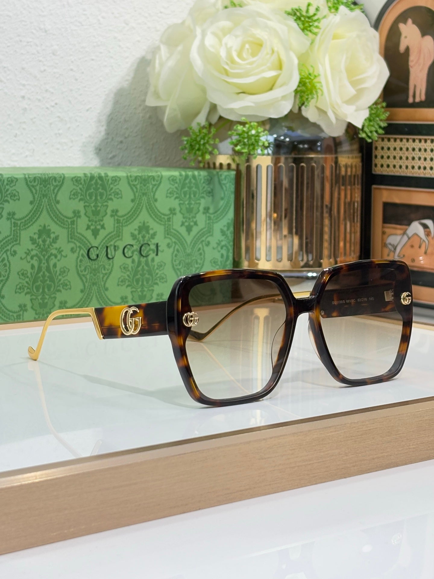 Gucci sunglasses with tortoiseshell frame, light gradient lenses, and gold logos