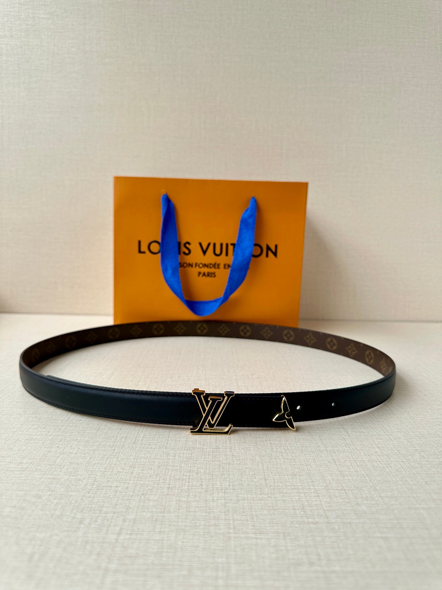 Louis Vuitton belt with dark blue leather strap and gold-tone LV buckle