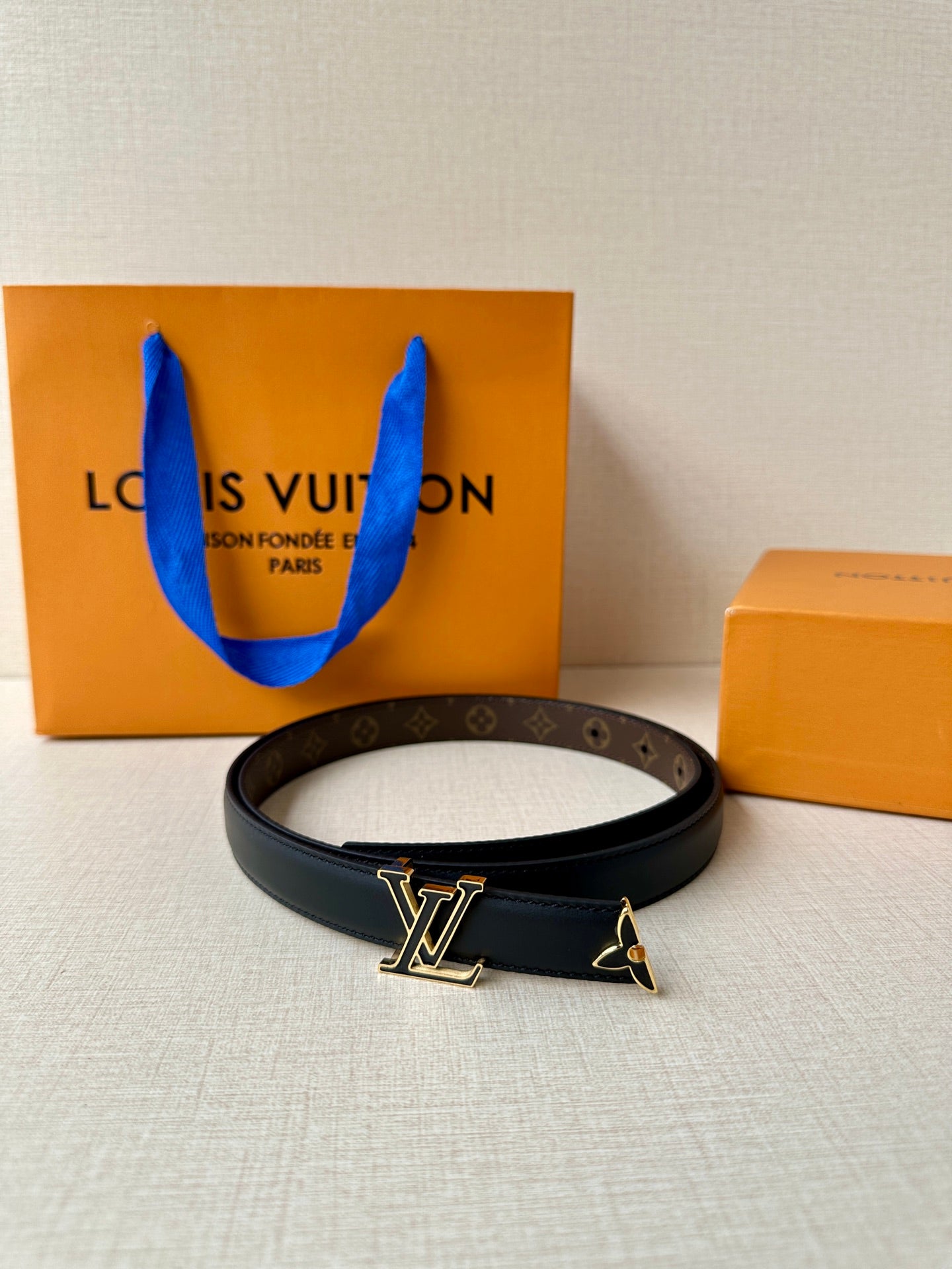 Louis Vuitton belt with dark blue leather strap and LV buckle on front view