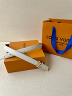 White leather belt with gold-tone LV buckle, belt end and keeper visible.