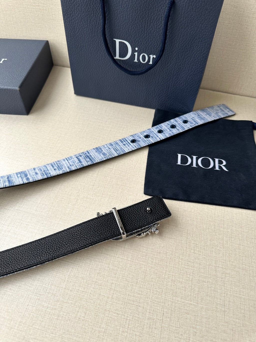 Dior belt detail: blue patterned strap and black strap with silver buckle