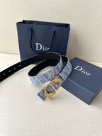 Dior belt with blue textured fabric strap and gold clasp buckle, shown on stand