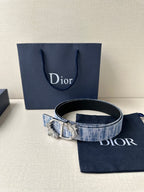 Dior belt with blue woven strap and gold buckle, displayed with navy pouch