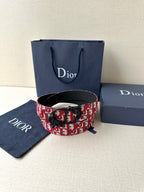 Dior belt display: red-and-black monogram strap with black buckle and clasp.