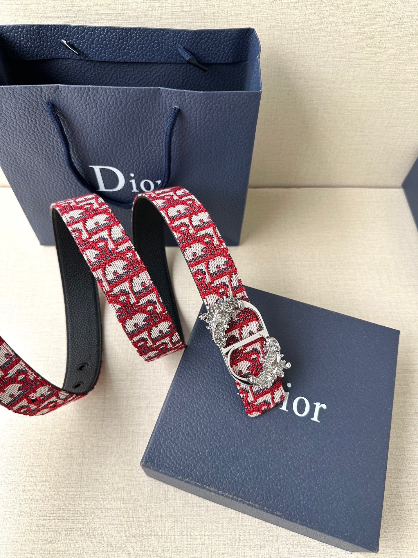Red monogram fabric belt with black leather strap and silver-tone lion buckle