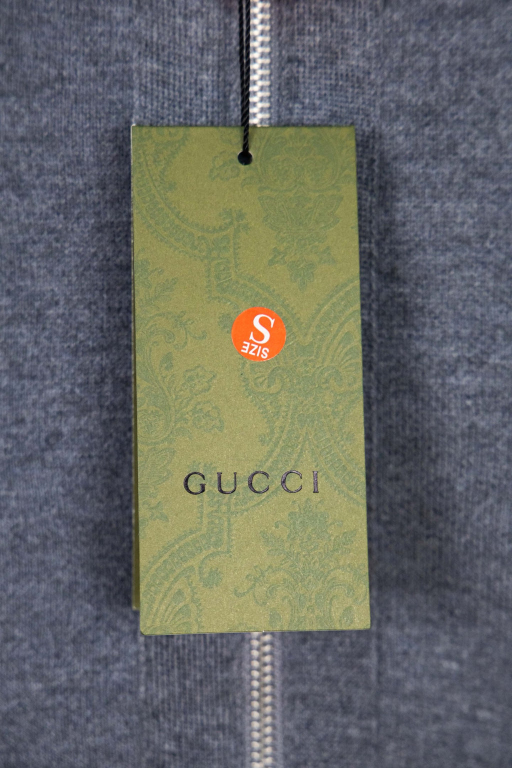 Green hang tag attached to the hoodie zipper, with Gucci branding