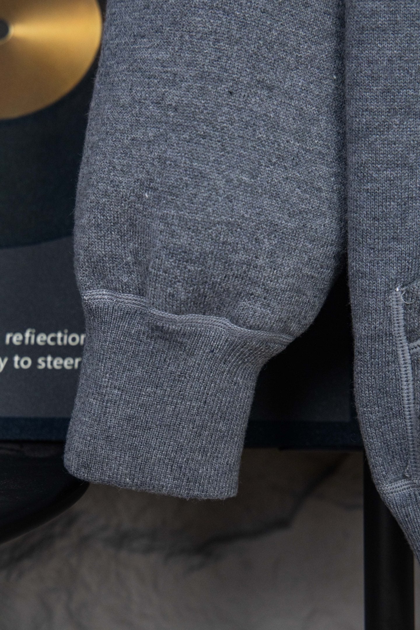 Heather gray hoodie sleeve cuff with ribbed hem and seam stitching detail