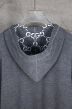 Heather gray zip-up hoodie with hood and dark logo print lining