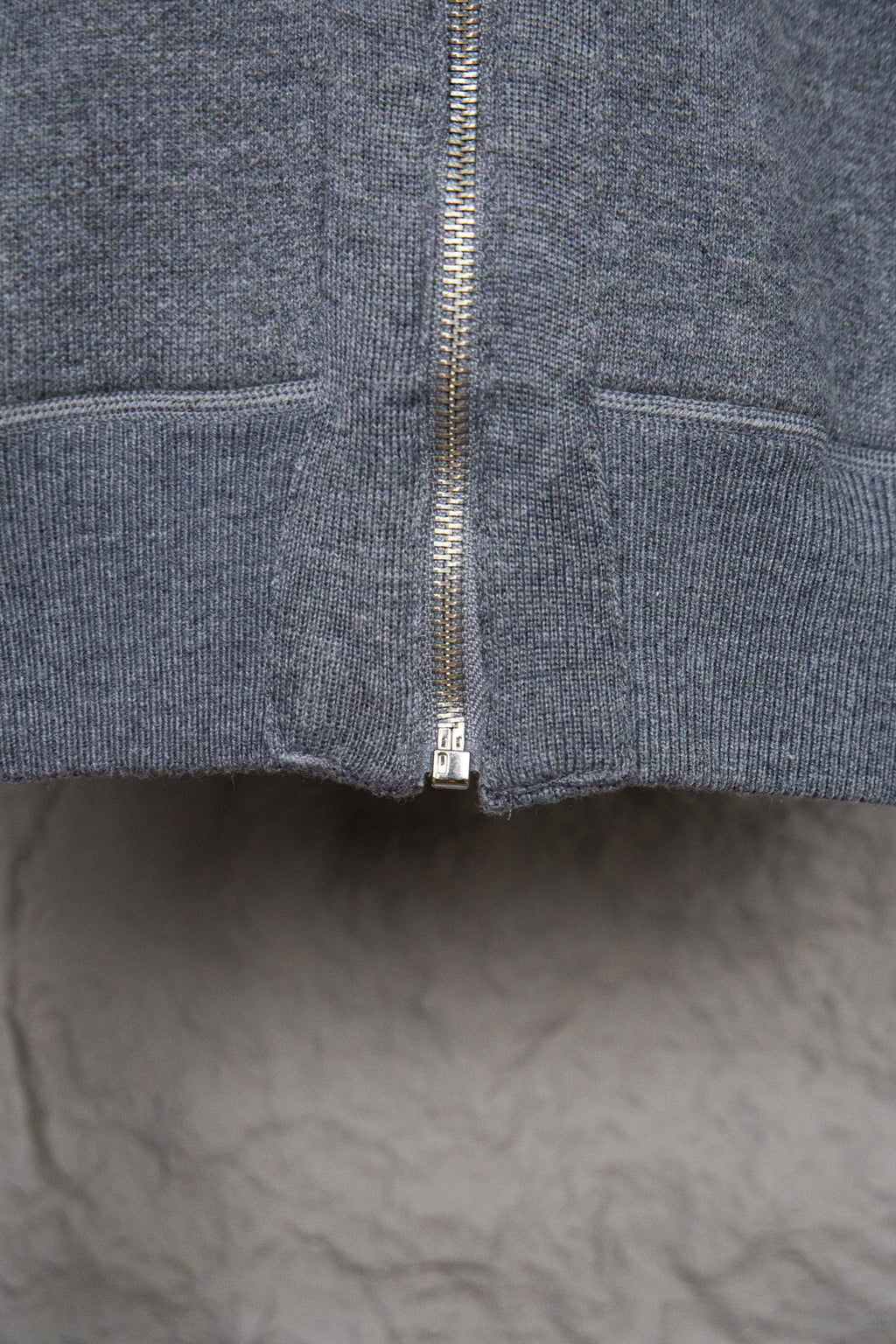 Heather gray hoodie front showing full zip and ribbed hem at bottom