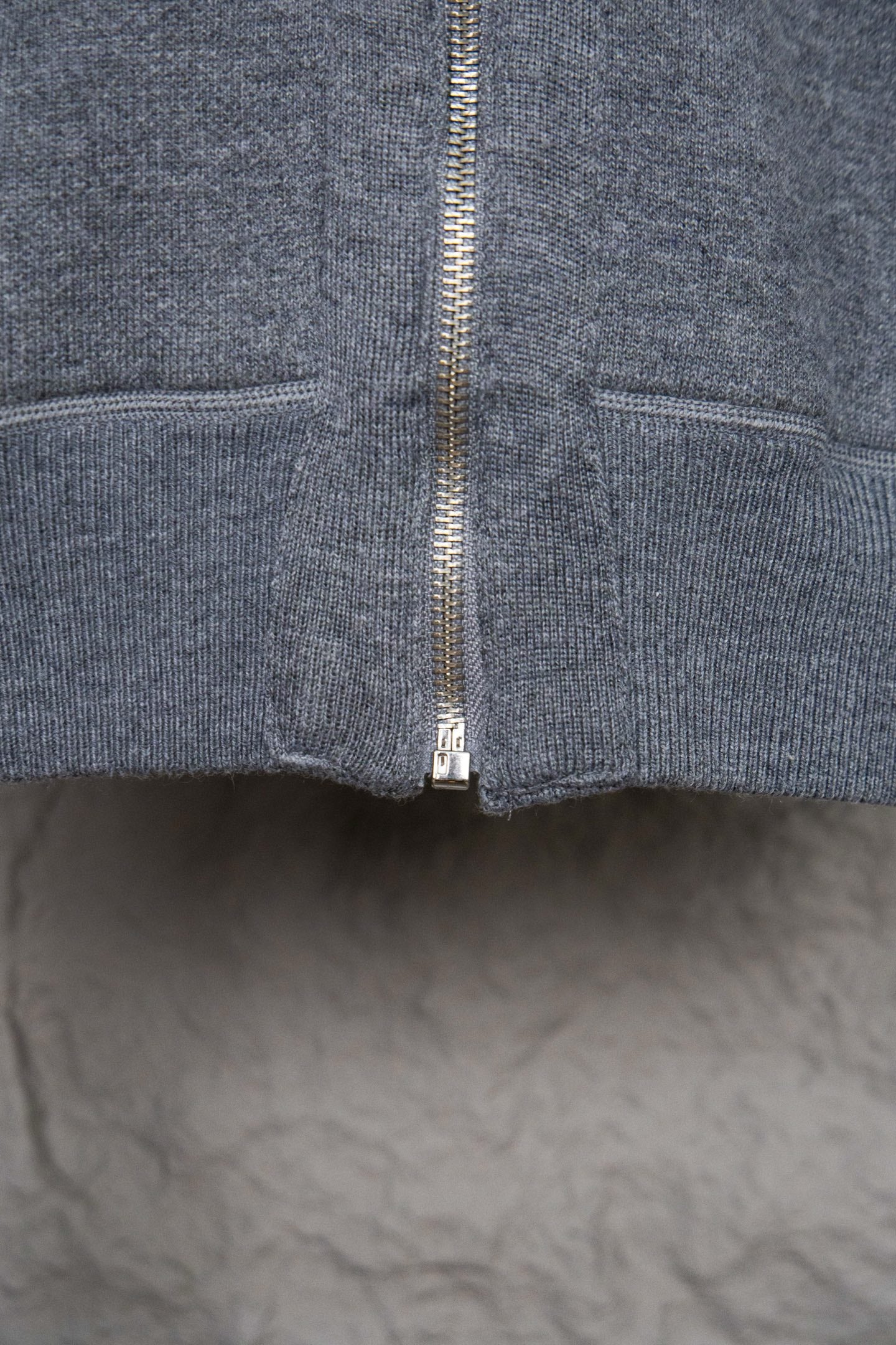 Heather gray hoodie front showing full zip and ribbed hem at bottom