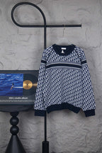 Long-sleeve knit sweater in dark blue with allover monogram pattern and striped hem