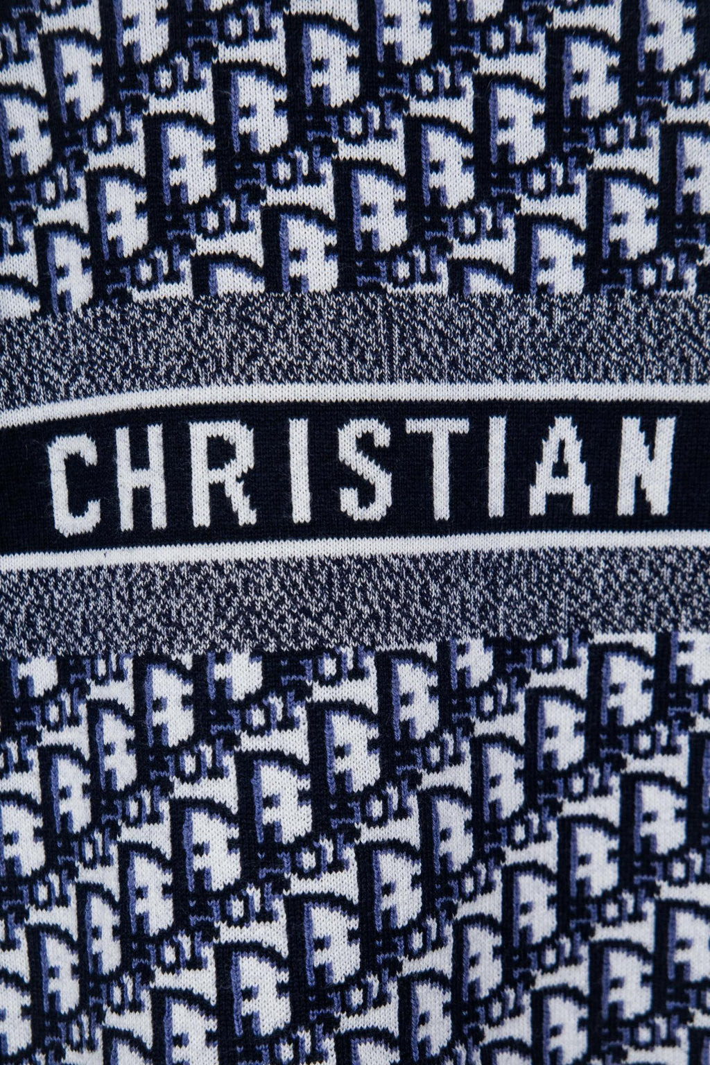Knit sweater band detail with CHRISTIAN text on striped logo panel