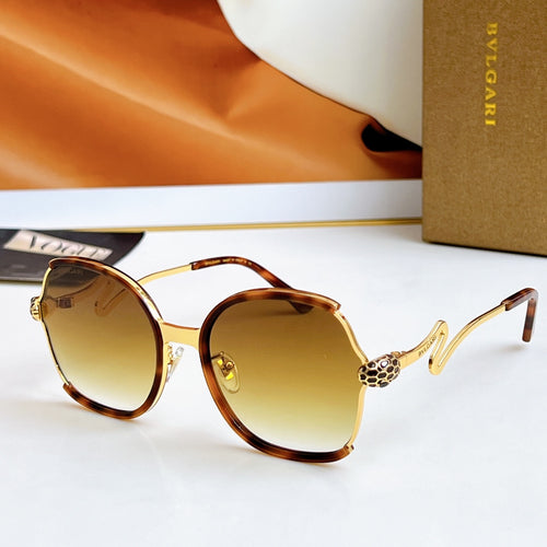 Sunglasses with tortoiseshell frames and gold-tone arms, brown gradient lenses