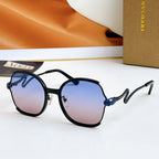 Sunglasses with black frames and gold-tone arms, blue jewel detail, dark lenses