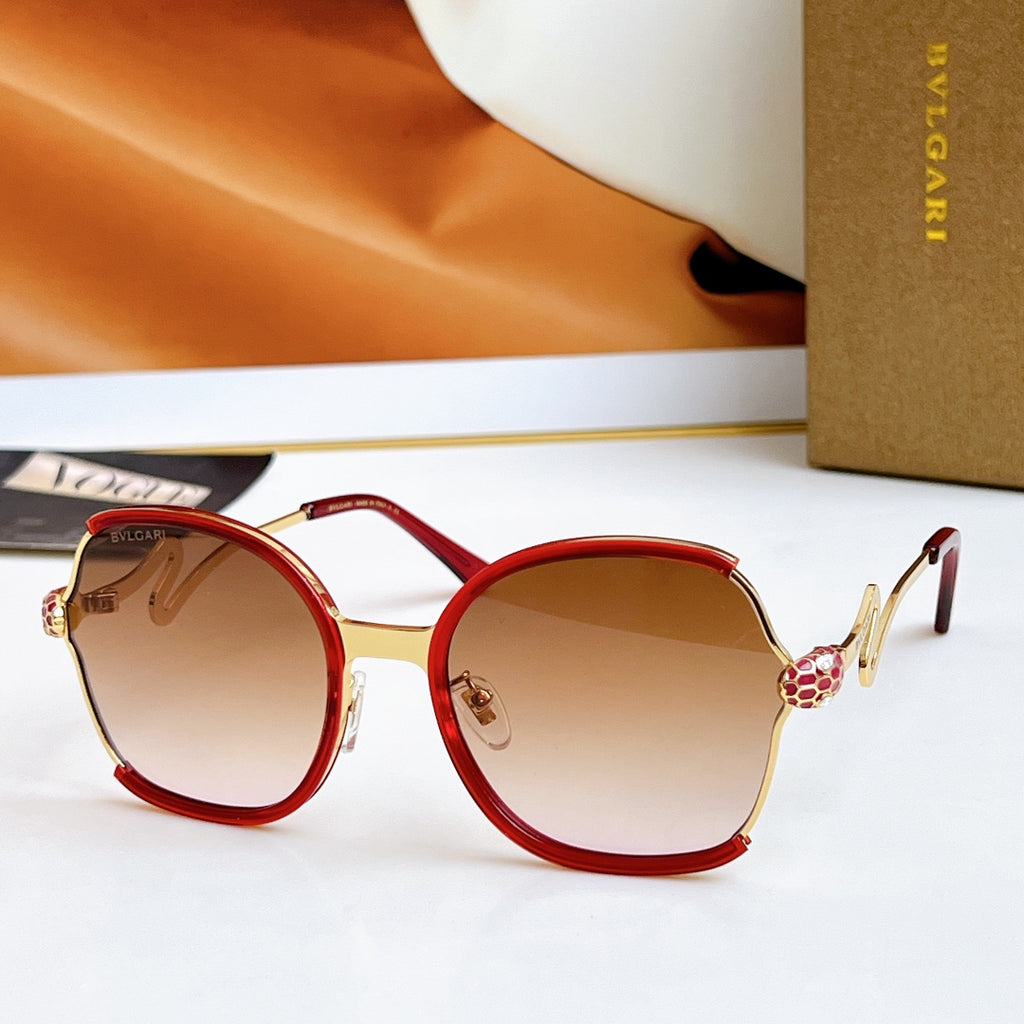 Sunglasses with red frames and gold-tone arms, amber gradient lenses
