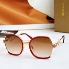 Sunglasses with red frames and gold-tone arms, amber gradient lenses