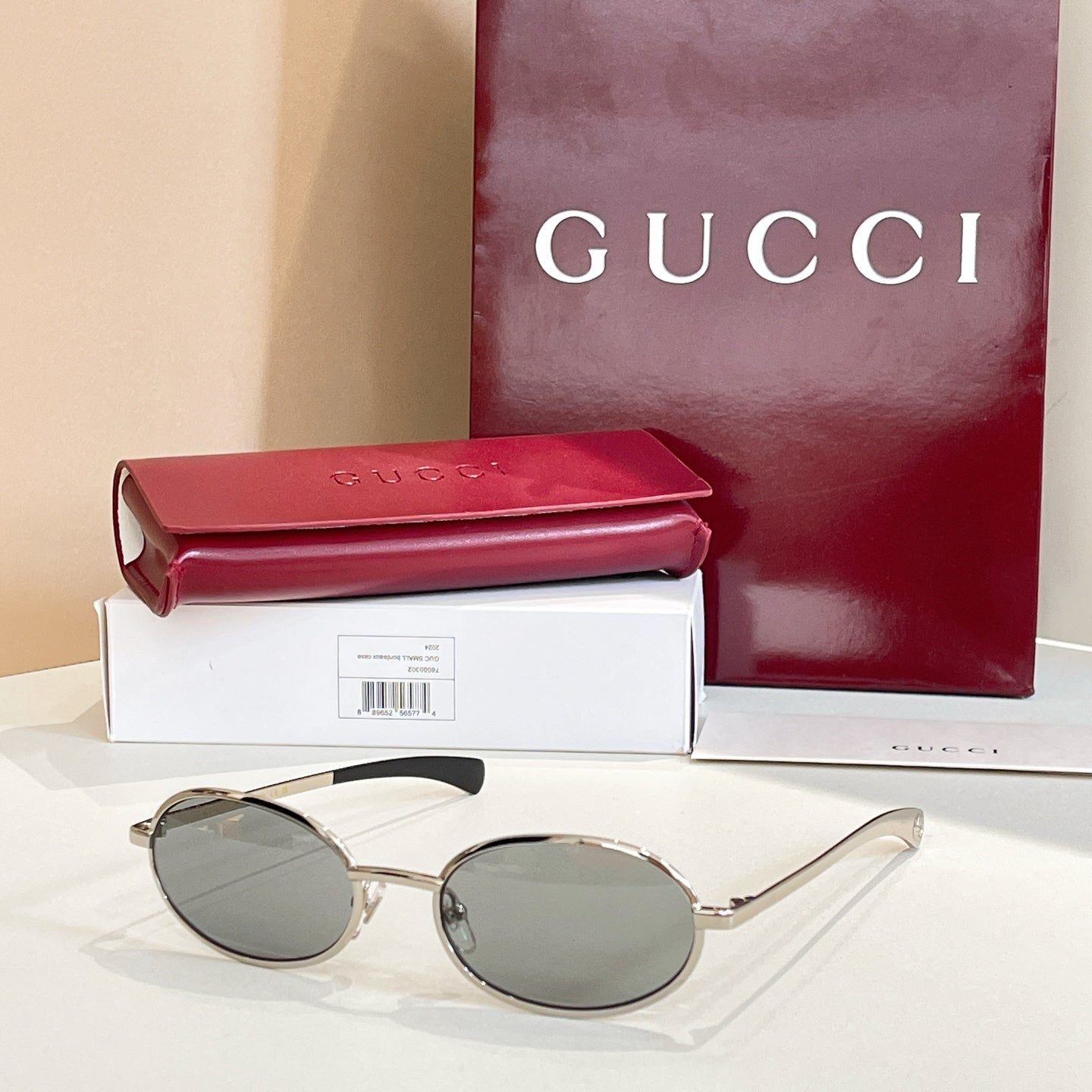 Gucci sunglasses with dark lenses and silver-tone oval-round frames