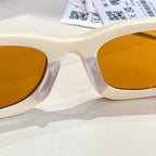 MiuMiu cream sunglasses close-up with amber lenses and gold-tone bridge detail